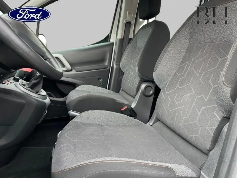 Vue intérieure côté conducteur du Peugeot Partner Tepee 2016, sièges tissu gris avec motifs géométriques.