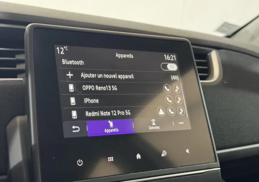Écran tactile central de la Renault ZOE Business blanc, affichant la connexion Bluetooth des appareils.