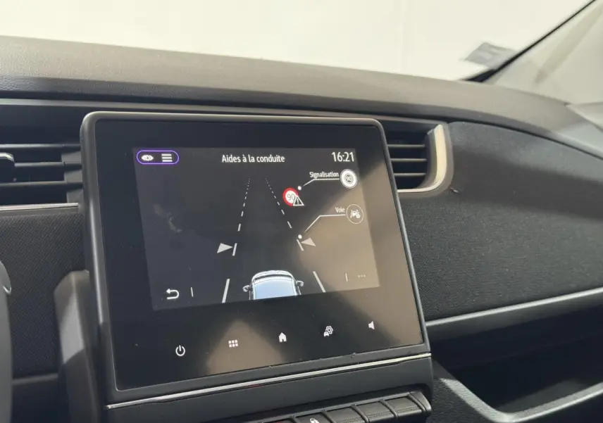 Écran tactile central affichant les aides à la conduite dans l'habitacle noir de la Renault ZOE blanche de 2020.