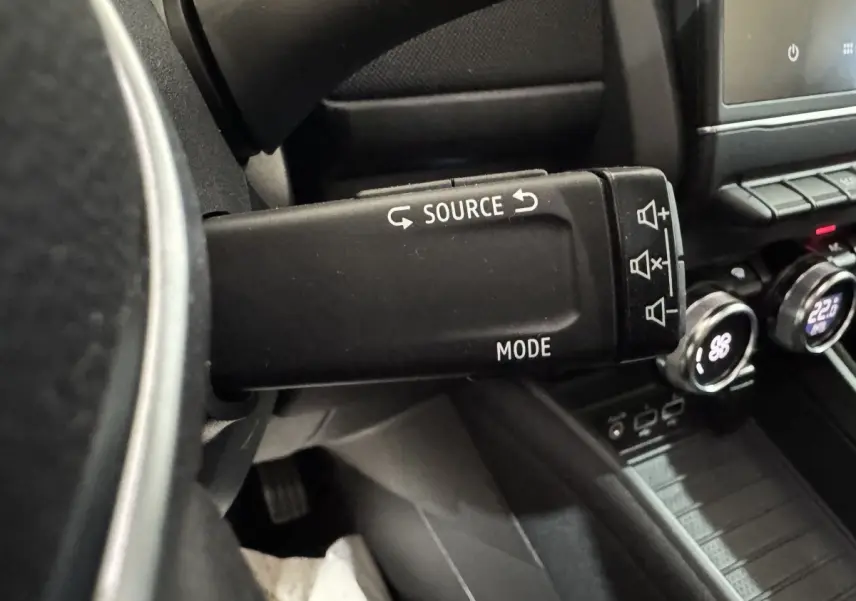 Gros plan sur la commande au volant noir de la Renault ZOE Business Rev R110 2020, avec tableau de bord et écran tactile visibles.