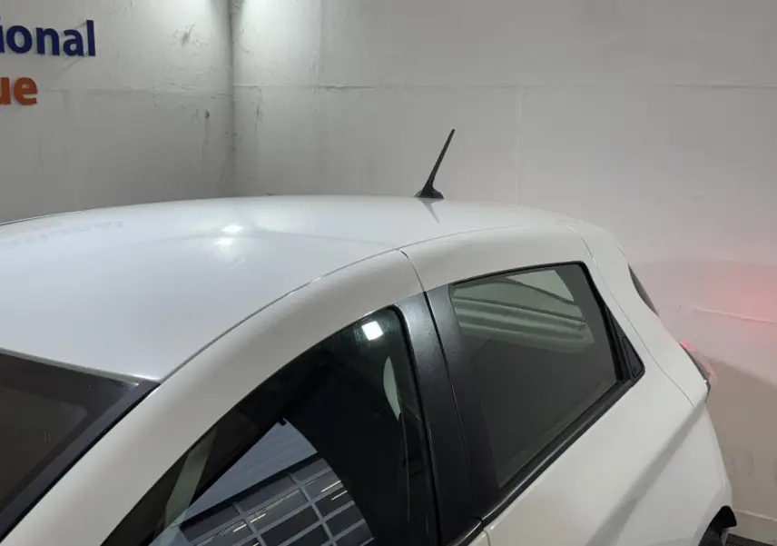 Vue 3/4 arrière droite d'une Renault ZOE Business blanche de 2020 avec antenne de toit et vitres teintées.