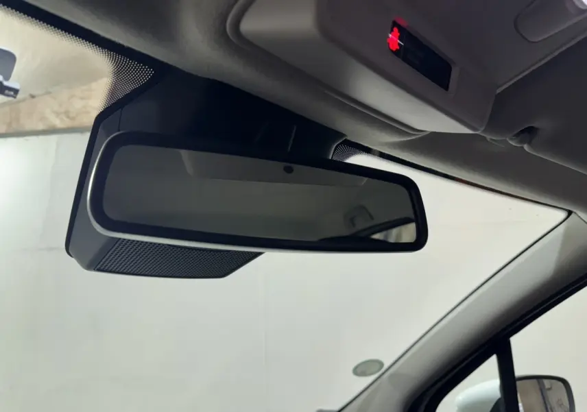 Gros plan sur le rétroviseur intérieur noir de la Renault ZOE Business Rev R110 blanche, vue côté conducteur.