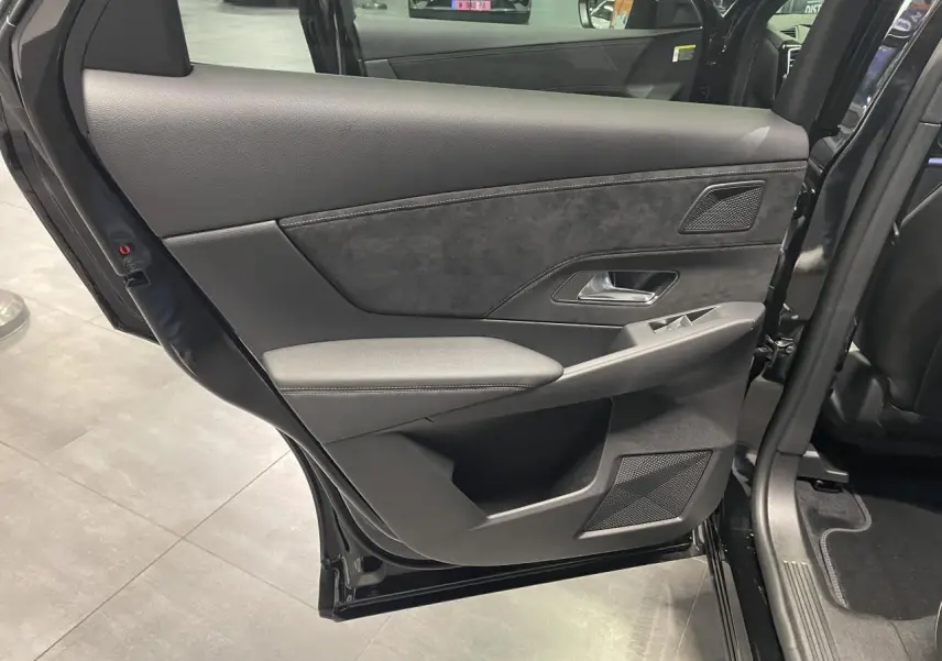 Vue intérieure côté gauche de la porte arrière noire métallisée du DS7 Crossback avec habillage Alcantara et commandes de vitres.
