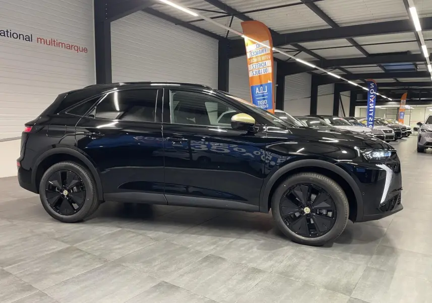 DS7 Crossback noir métallisé vu de profil côté gauche, avec jantes noires et coques de rétroviseur dorées satinées.