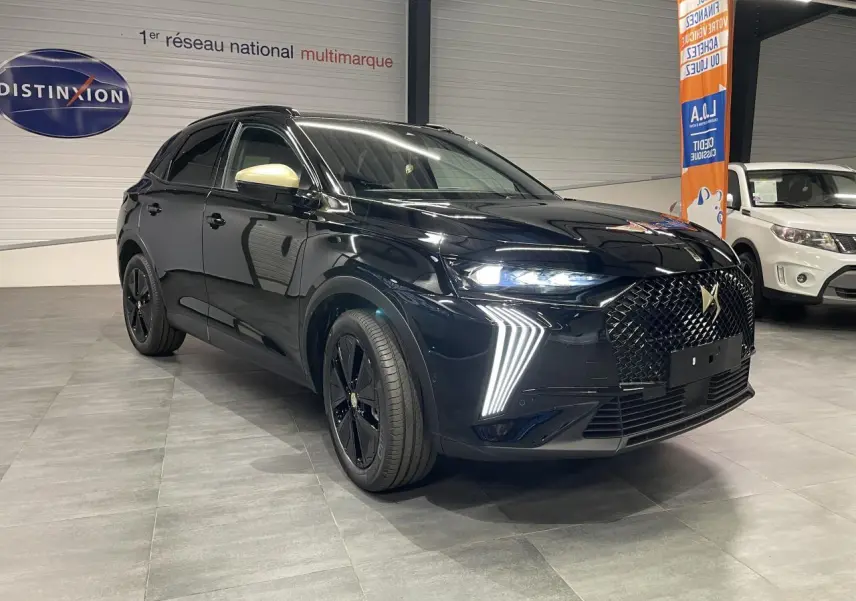 DS7 Crossback noir métallisé en 3/4 avant droit avec calandre DS Wings et feux LED verticaux allumés.