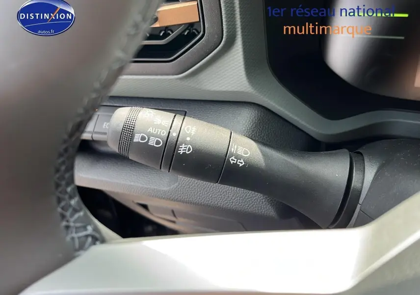 Gros plan sur la commande des phares et clignotants du Dacia Duster 2025 noir, vue depuis le volant côté gauche.