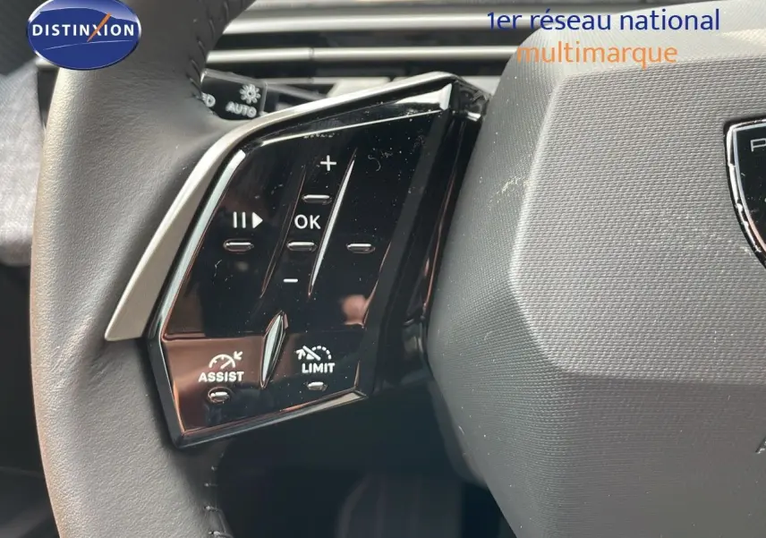 Gros plan sur les commandes gauche du volant du Peugeot 3008 Hybrid gris Artense, avec boutons de régulateur et limiteur de vitesse.