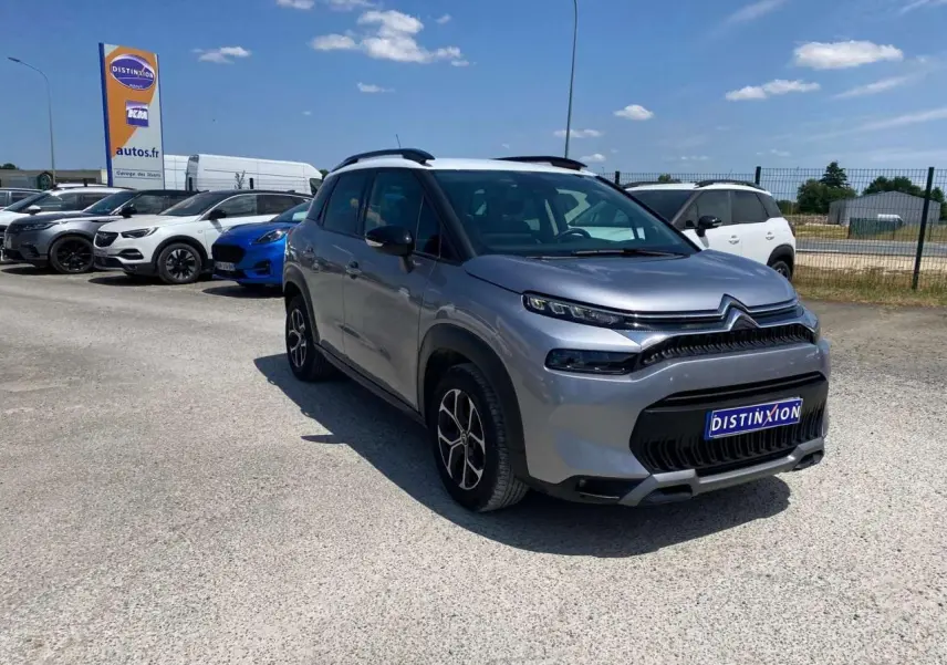 Citroën C3 Aircross gris Artense avec toit blanc, vue 3/4 avant droit sur parking ensoleillé.