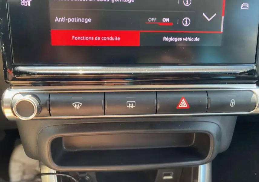 Gros plan sur la console centrale de la Citroën C3 Aircross 2023, montrant les commandes de climatisation et sécurité.