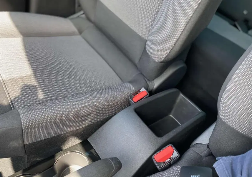 Gros plan sur la console centrale entre les sièges avant gris foncé du Citroën C3 Aircross 2023 finition Shine.