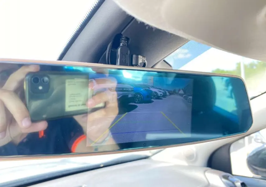 Rétroviseur intérieur numérique affichant la caméra de recul du Citroën C3 Aircross gris avec toit blanc, vue arrière du parking.