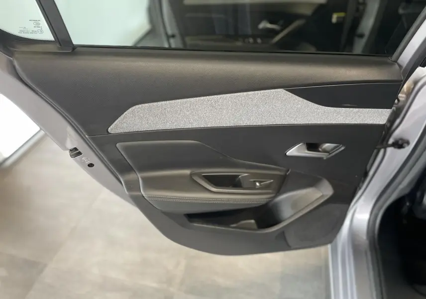Gros plan sur la porte arrière gauche gris Artense de la Peugeot 308 2022 avec insert textile gris et poignée argentée.
