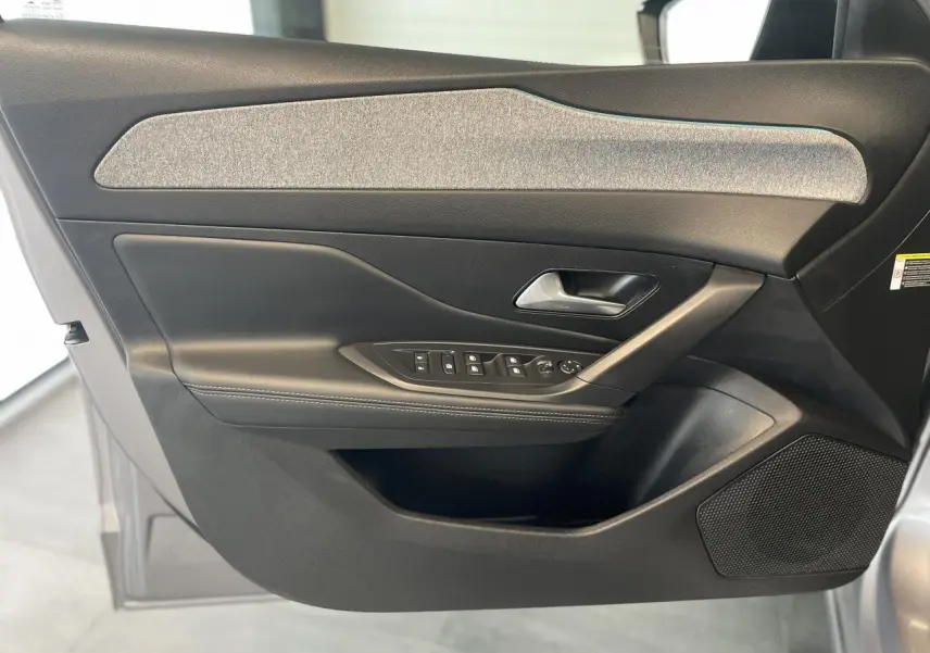 Intérieur côté gauche de la porte avant gris Artense du Peugeot 308 2022 avec commandes de vitres et poignée métallique.