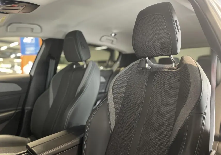 Gros plan sur les sièges avant en sellerie tri matières noire et grise du Peugeot 308 Allure Pack 2022.