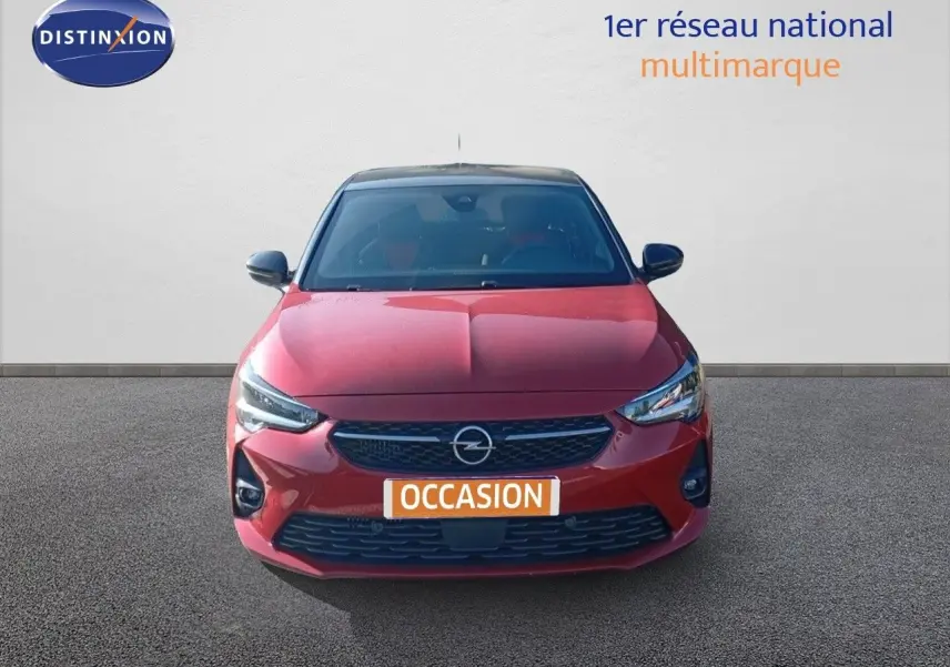 Vue de face d'une Opel Corsa rouge Kardio Metal avec toit noir, affichant ses phares LED et calandre distinctive.
