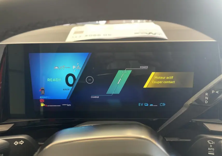 Vue de face du tableau de bord numérique de la Renault Rafale rouge, affichant l'état moteur et mode Eco.