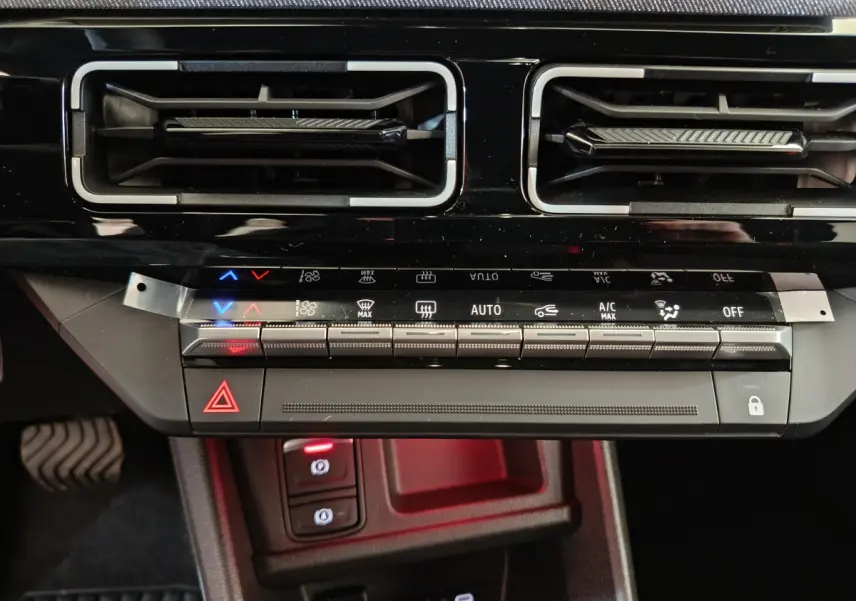 Détail du tableau de bord noir de la Renault R5 Techno 150 ch, avec commandes climatisation et boutons lumineux.
