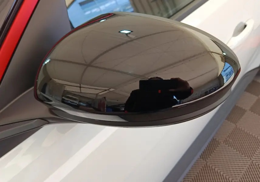 Rétroviseur extérieur droit noir brillant sur Renault R5 Techno blanc, vue rapprochée sur porte et poignée.