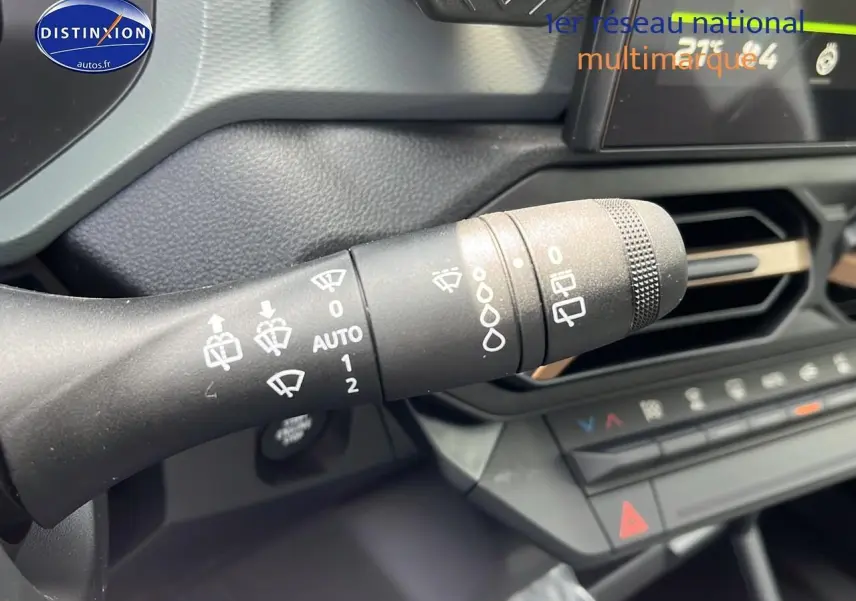 Gros plan sur la commande des essuie-glaces dans l'habitacle du Dacia Duster noir 2025, tableau de bord visible.