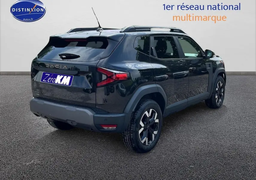 Vue 3/4 arrière droite d'un Dacia Duster noir 2025 avec jantes alu et barres de toit visibles.