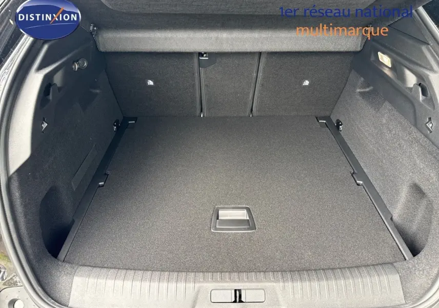 Coffre spacieux ouvert d'un Peugeot 3008 Hybrid noir perle métal, vue arrière avec plancher plat et habillage noir.