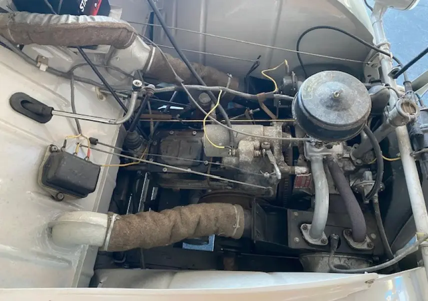 Moteur essence de la Citroën 2 CV beige clair de 1968, vue plongeante sur le compartiment moteur refait à neuf.