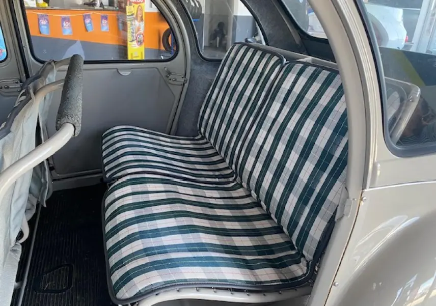 Banquette arrière à motifs rayés verts et blancs dans une Citroën 2 CV beige clair refaite à neuf, vue côté droit intérieur.