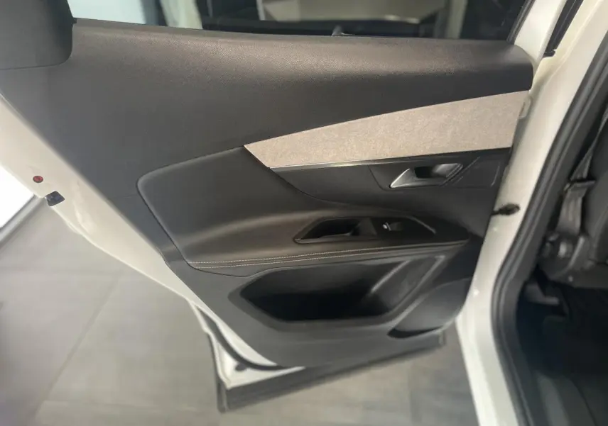 Porte arrière gauche ouverte du Peugeot 3008 blanc nacré, avec garniture intérieure noire et insert gris clair.