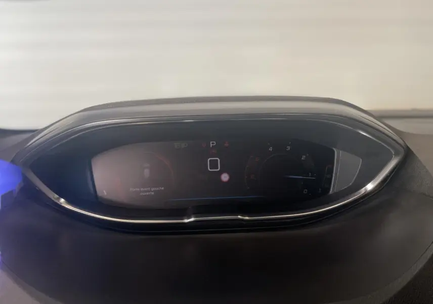 Combiné numérique du tableau de bord du Peugeot 3008 GT 2022, affichant la vitesse et alertes, entouré de chrome.