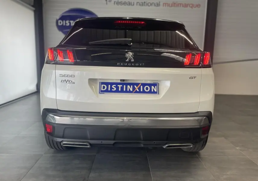 Vue arrière d'un Peugeot 3008 GT blanc nacré avec feux LED et double sortie d'échappement chromée.
