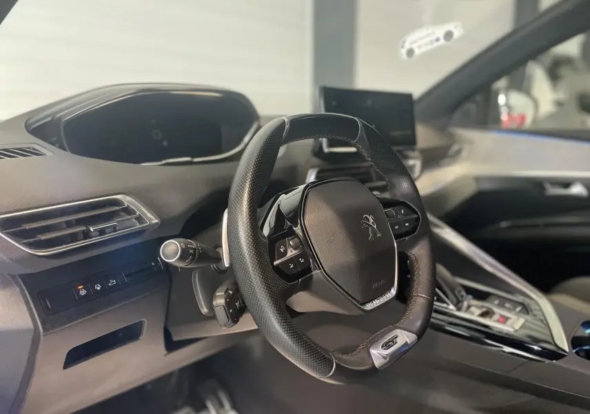 Vue intérieure du volant compact cuir perforé Peugeot 3008 GT 2022 avec tableau de bord et écran tactile.