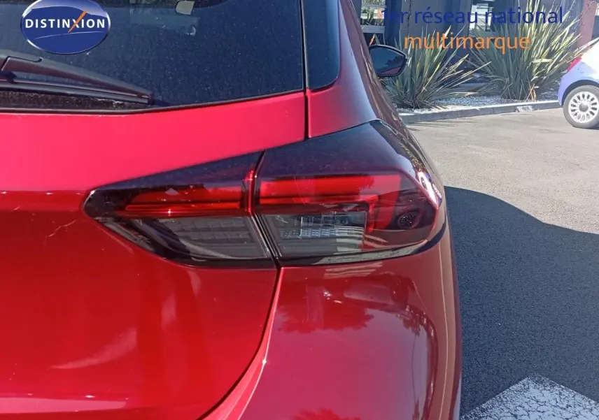 Gros plan sur le feu arrière droit d'une Opel Corsa 2023 rouge Kardio métal avec toit noir, vue arrière côté droit.