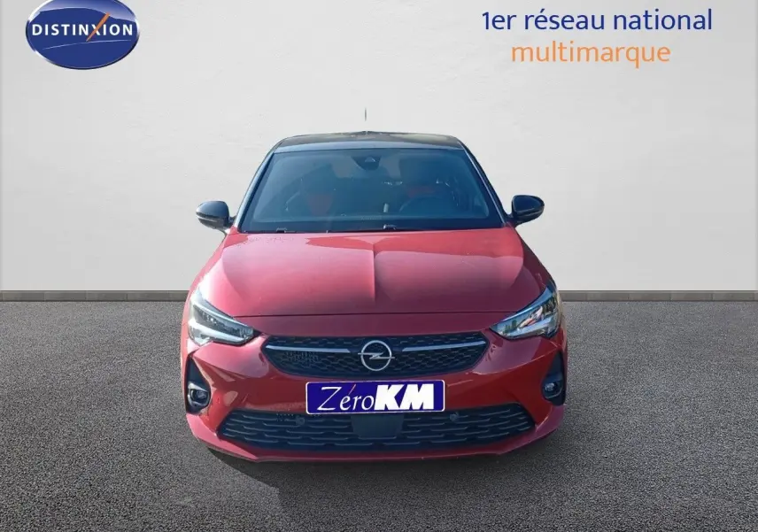 Opel Corsa 2023 rouge Kardio métal avec toit noir vue de face mettant en valeur ses phares LED et calandre noire.