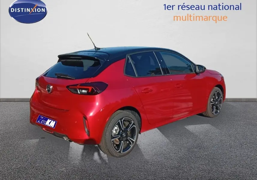 Vue 3/4 arrière droite d'une Opel Corsa rouge Kardio métal avec toit noir et jantes alliage noires.
