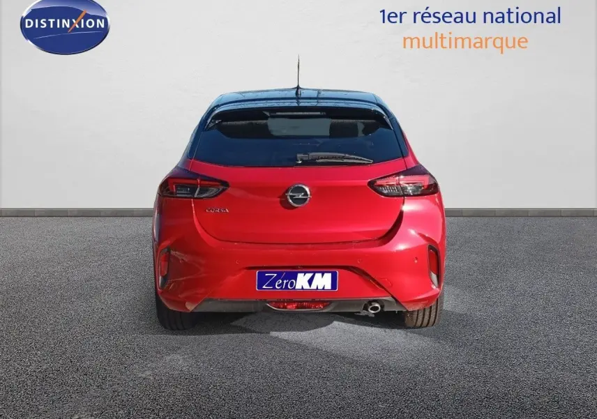 Vue arrière d'une Opel Corsa rouge Kardio métal avec toit noir, affichant son logo et feux LED distinctifs.