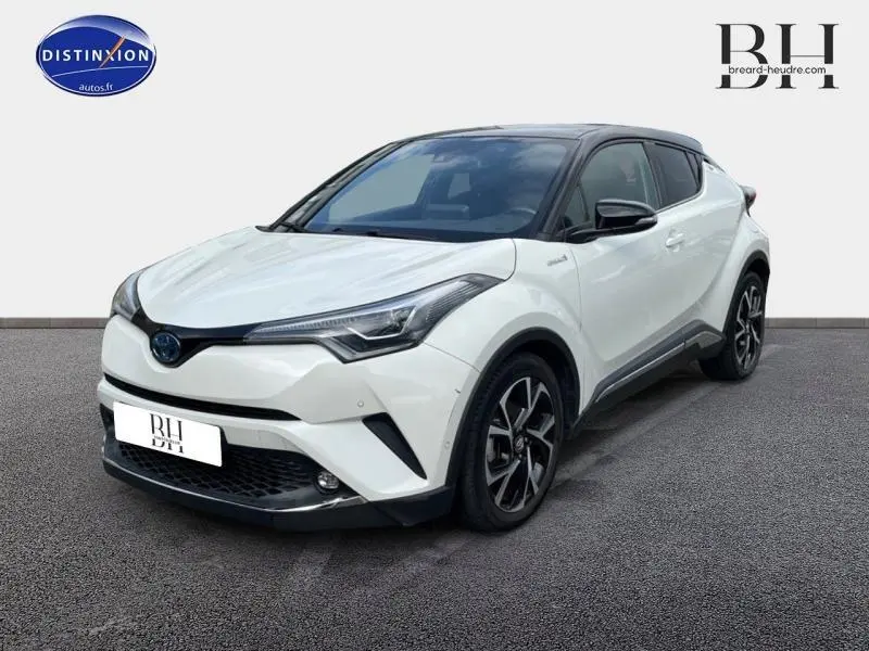 Toyota C-HR 122h Collection blanc nacré bi-ton en vue 3/4 avant, soulignant son design moderne et ses jantes alu noires.