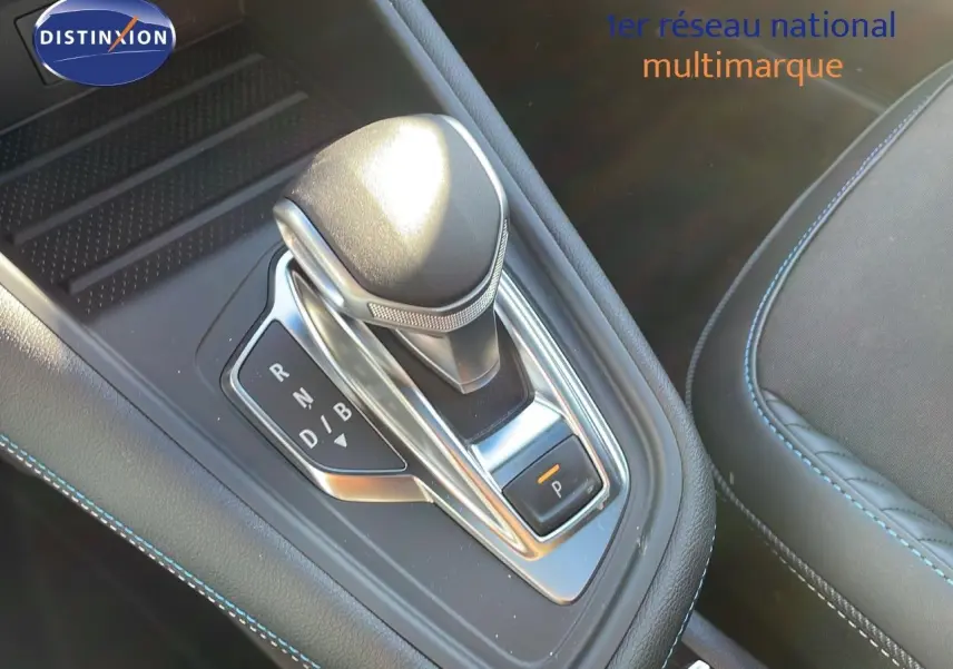 Le levier de vitesses automatique du Renault Captur E-Tech hybride 2025, avec coutures bleues sur console noire.