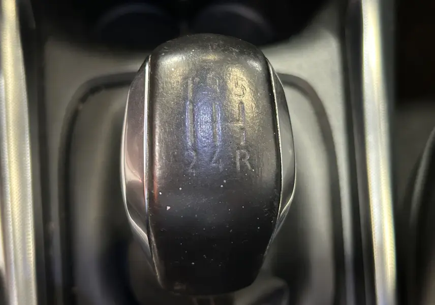 Gros plan sur le levier de vitesses noir de la Peugeot 2008 VTi 82 Allure, boîte manuelle, intérieur sombre.