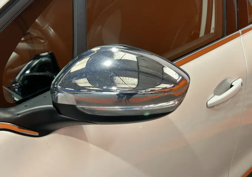 Rétroviseur chromé côté gauche d'une Peugeot 2008 blanche, avec poignée de porte visible en arrière-plan.