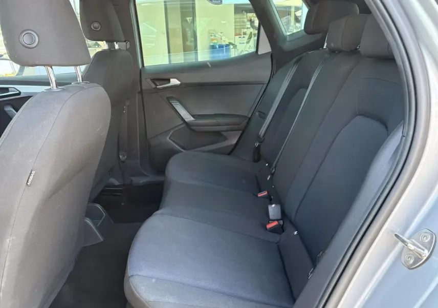 Vue latérale droite de l'habitacle arrière du SEAT Arona 2024 en gris, avec banquette textile noire et appuie-têtes.