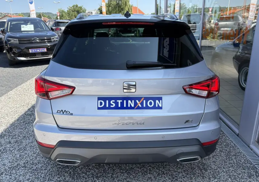 Vue arrière d'une SEAT Arona 2024 gris clair avec feux LED et double sortie d'échappement intégrée.