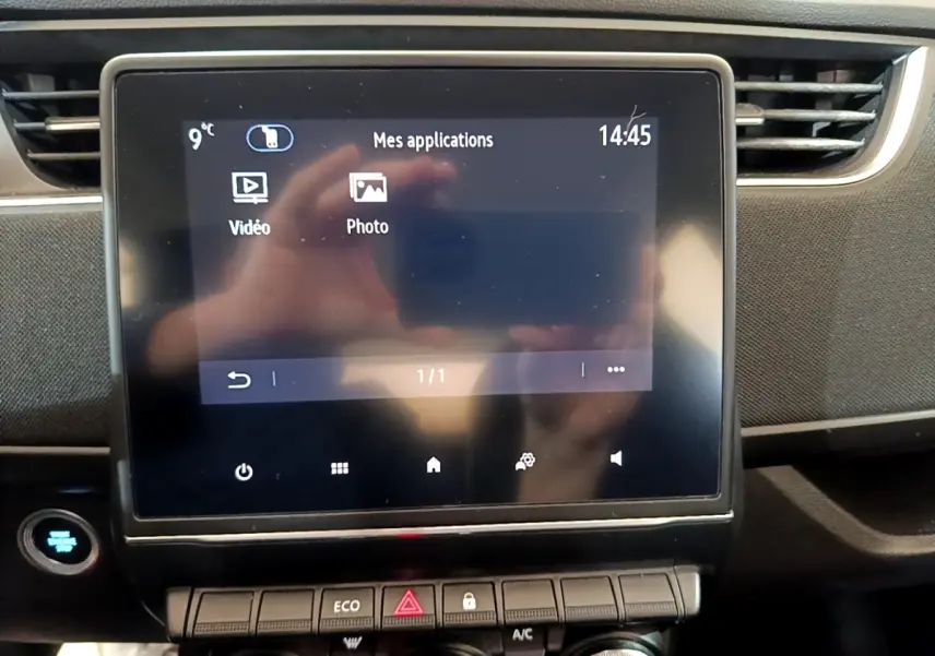 Écran tactile central de la Renault ZOE Business R110 2021, affichant les applications vidéo et photo, avec tableau de bord noir.