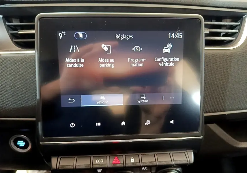 Écran tactile central de la Renault ZOE Business R110 blanc, affichant les réglages d’aides à la conduite et parking.