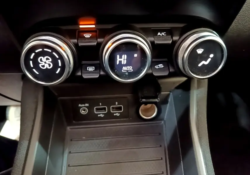 Gros plan sur les commandes de climatisation et les ports USB d'une Renault ZOE Business R110 blanche de 2021.