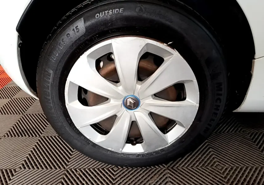 Gros plan sur la roue avant droite blanche d'une Renault ZOE Business R110 2021 avec jante en plastique et logo Renault.