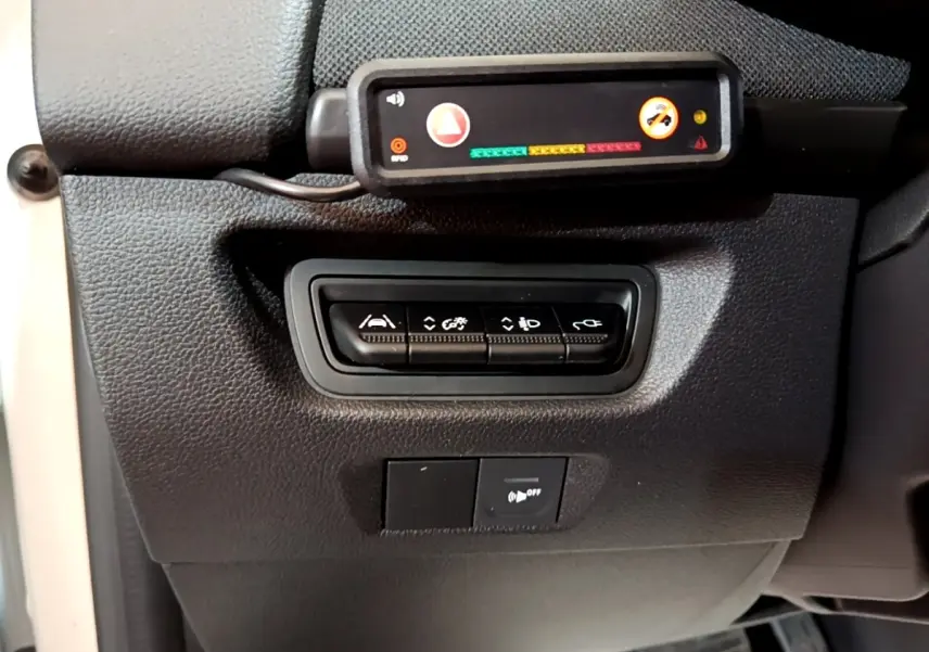 Gros plan sur les commandes de réglages et capteurs situés à gauche du volant dans une Renault ZOE Business R110 blanche de 2021.