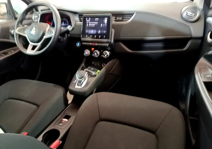 Vue intérieure avant de la Renault ZOE Business R110 2021, tableau de bord noir avec écran tactile central et volant multifonctions.