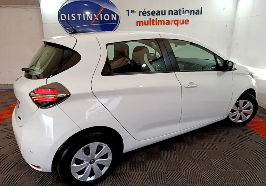 Vue 3/4 arrière droite d'une Renault ZOE Business R110 blanche, avec feux arrière LED et jantes acier.