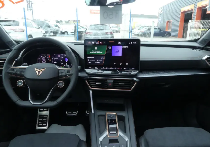 Intérieur avant du Cupra Formentor gris Graphène 2025, tableau de bord noir avec écran tactile central et volant multifonction.