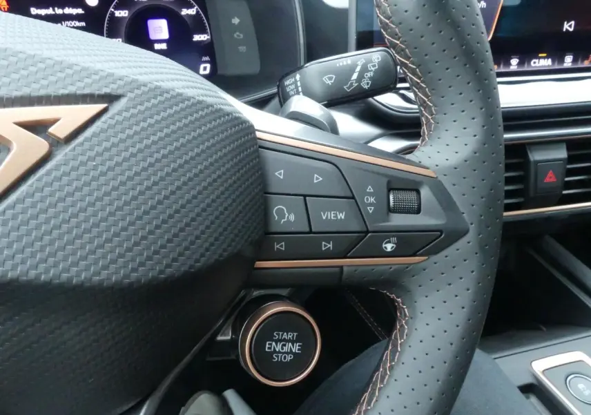 Gros plan sur le volant perforé noir avec logo CUPRA cuivré et commandes multifonctions du CUPRA Formentor 2025.